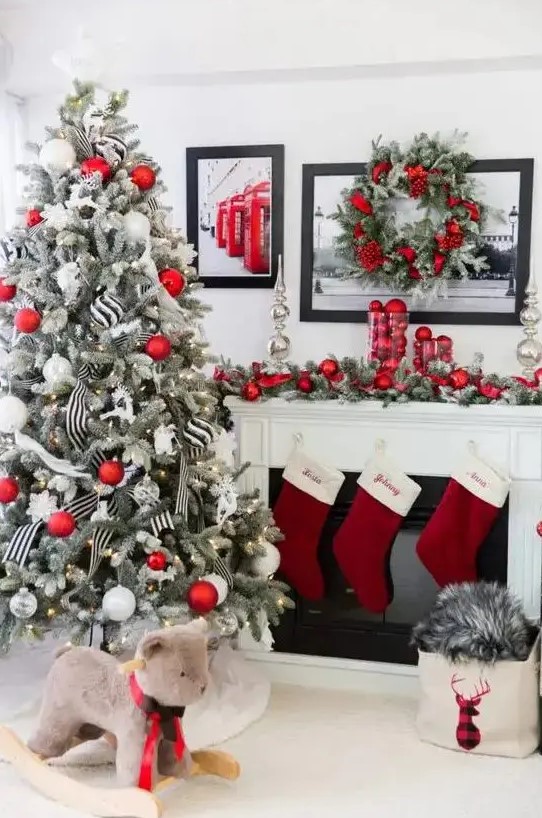 a flocked Christmas tree with red and white ornaments, with lights and black and white striped ribbons