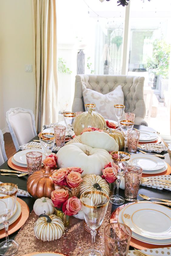 a glam Thanksgiving centerpiece of pink roses, white, copper and gold pumpkins plus a rose gold sequin table runner is a very cute idea