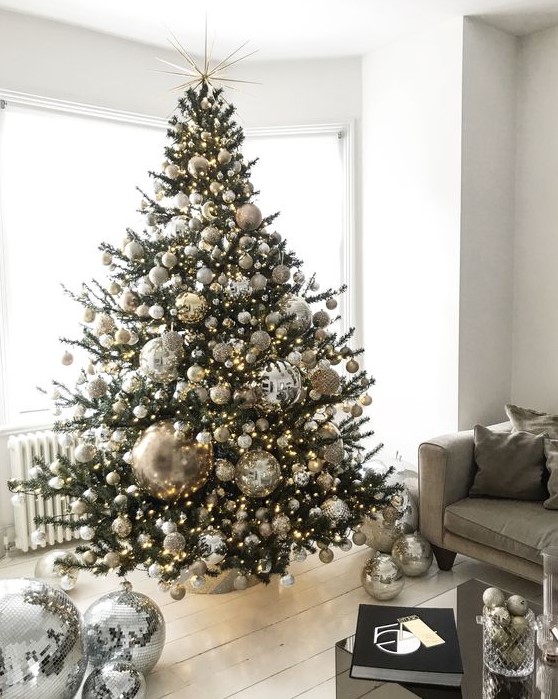 a jaw-dropping Christmas tree with silver, gold and glitter ornaments and oversized disco balls plus lights is ideal for party lovers