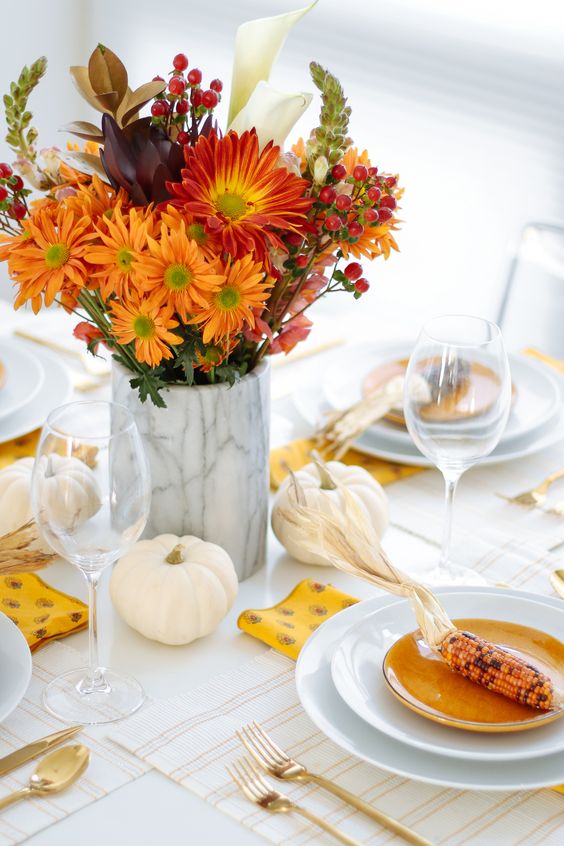a lovely Thanksgiving centerpiece of white pumpkins, a marble vase with super bold blooms and berries is awesome