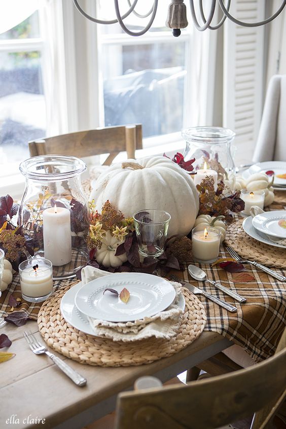 a lovely and cozy Thanksgiving harvest centerpiece of bold foliage, candles is a gorgeous idea for this holiday