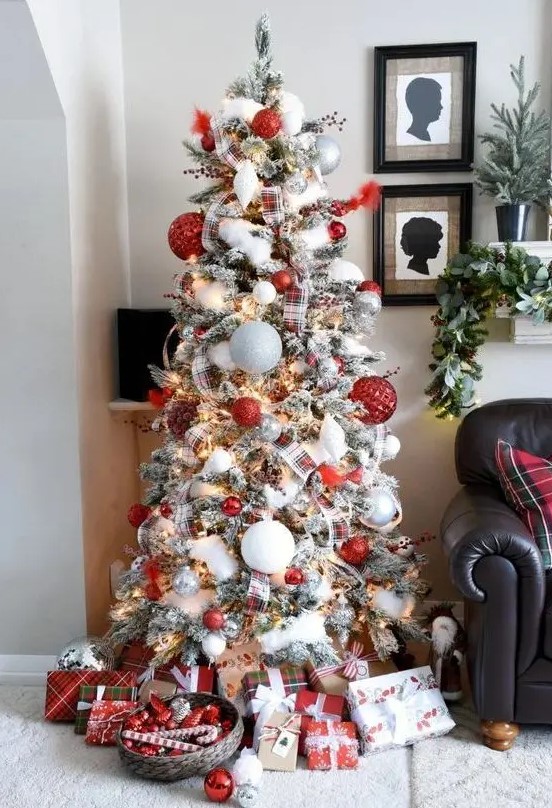 a lovely modern flocked Christmas tree with oversized white, silver and red textural ornaments, smaller ones, plaid ribbons and faux snow plus lights