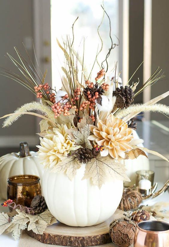 a lovely textural and dimensional Thanksgiving centerpiece of leaves, neutral blooms, berries, twigs and pinecones is wow