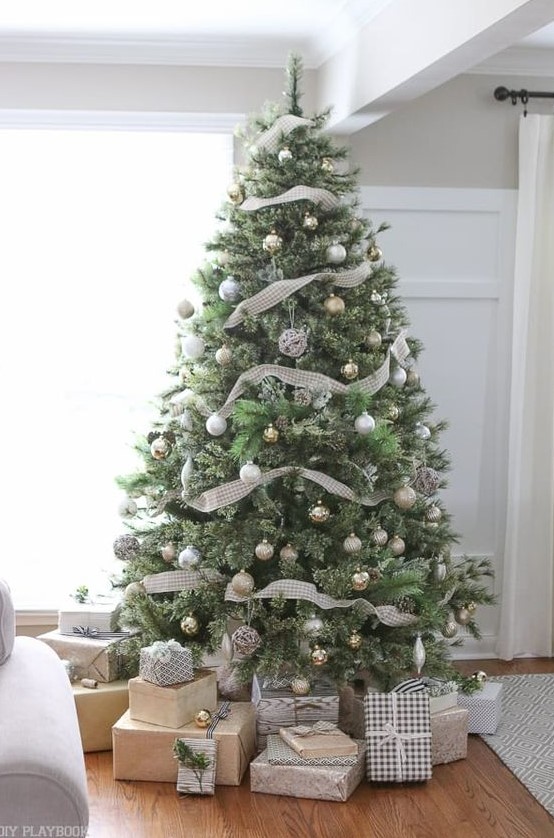 a neutral Christmas tree with lots of metallic ornaments and plaid ribbons looks very calm and cute