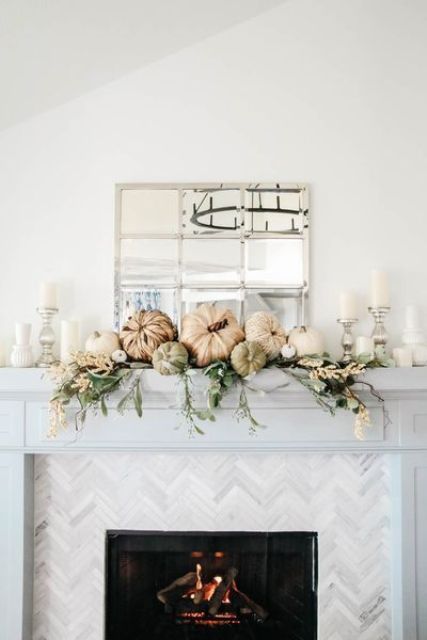 a neutral Thanksgiving mantel with greenery, white blooms, pumpkins and neutral candles is chic and beautiful