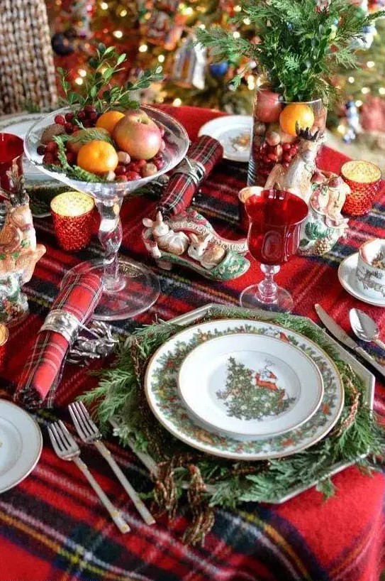 a plaid tablecloth and napkins add a cozy traditional feel to the table, and evergreens make it lively