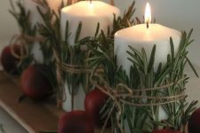 a planked board with candles wrapped with herbs and some faux apples is a great decor idea for fall and Thanksgiving