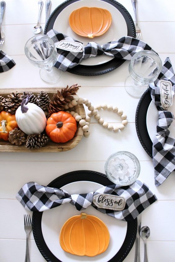 a pretty and cool Thanksgiving centerpiece of a dough bowl with pinecones and faux pumpkins plus some wooden beads is easy to recreate