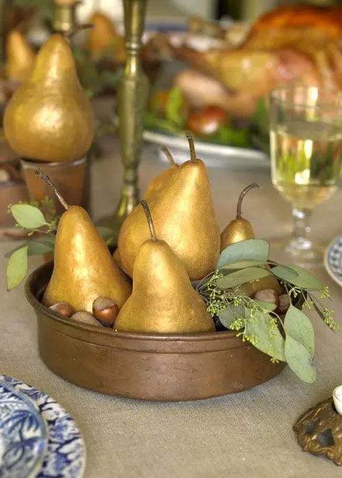 a rustic Thanksgiving centerpiece of a bowl with nuts, gidled pears and greenery is a pretty last minute idea that you can easily realize