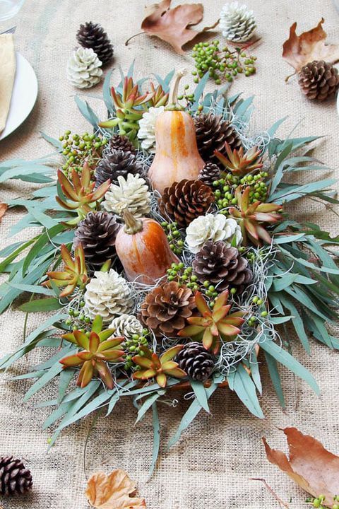 a rustic Thanksgiving centerpiece of greenery, sucuclents, pinecones and gourds is a lovely idea for a party