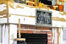 a shabby chic Thanksgiving mantel with lanterns with pumpkins, books, bold velvet pumpkins and pinecones