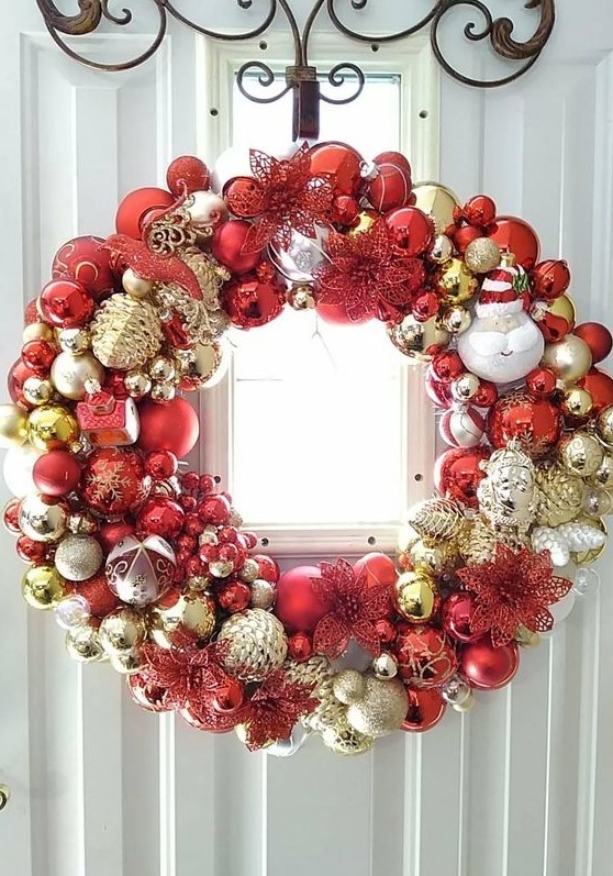 a shiny Christmas wreath fully made of ornaments, in gold, silver and red, of various sizes and looks