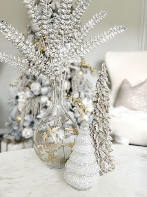 a silver Christmas arrangement with silver foliage, a snowy Christmas tree and a glass one is beautiful