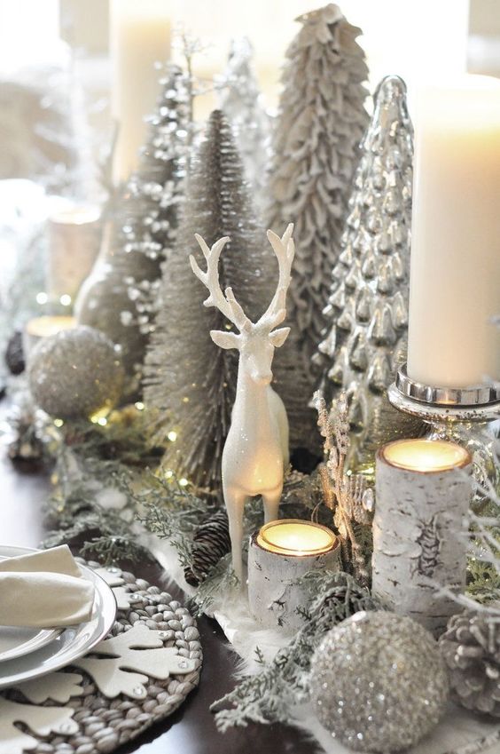 a silver Christmas centerpiece of silver glitter ornaments, silver evergreens, candleholders, silver Christmas trees