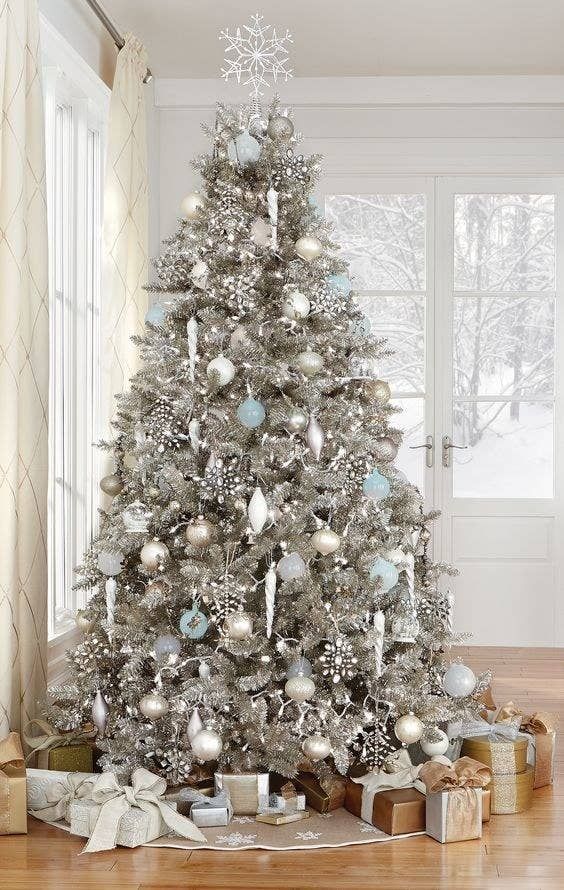 a silver Christmas tree decorated with white, silver and light blue ornaments, rhinestone snowflakes and lights plus a snowflake topper