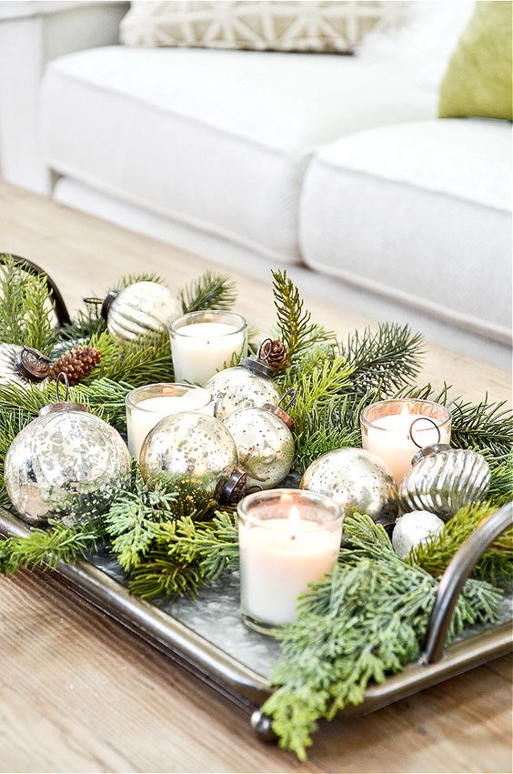 a tray with evergreens, silver ornaments, pinecones and candles is a lovely decoration or a centerpiece for Christmas