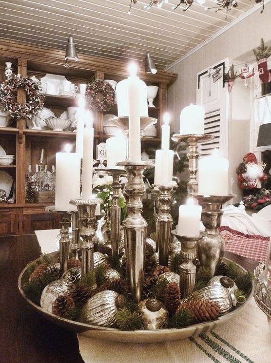 a tray with pinecones, evergreens, silver ornaments and silver candle holders is a beautiful Christmas centerpiece