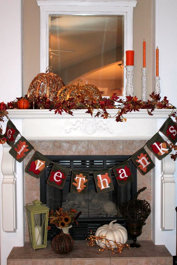 a vintage Thanksgiving mantel with bold leaves, pumpkins of porcelain and lights, a fabric garland and orange candles