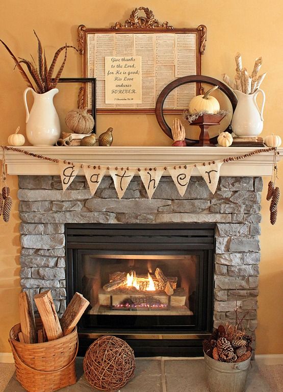 a vintage and rustic Thanksgiving mantel with a wooden bead and burlap garland plus pinecones in a bucket, mini pumpkins, feathers, ,etal gourds and signs