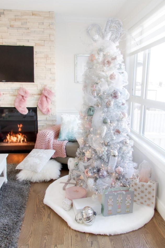 a white Christmas tree styled with pastel green, pink and silver ornaments and with gifts packed in matching boxes
