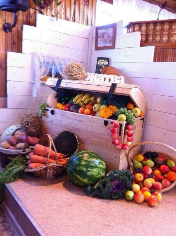 a wooden chest with lots of veggies and fruits and baskets with them around is a pretty rustic decoration to rock