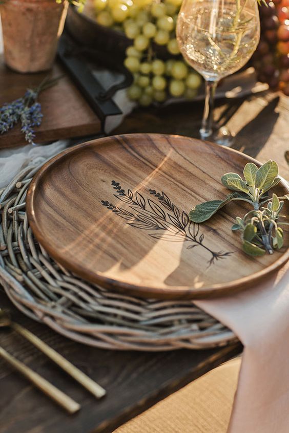 a woven placemat and a wooden plate with wood burning for a lovely farmhouse-inspired Thanksgiving tablescape