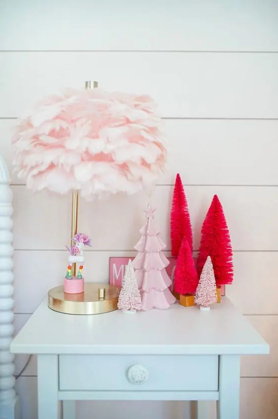 an arrangement of faux Christmas trees - bottlebrush ones and a porcelain one in pink and red for a girlish feel