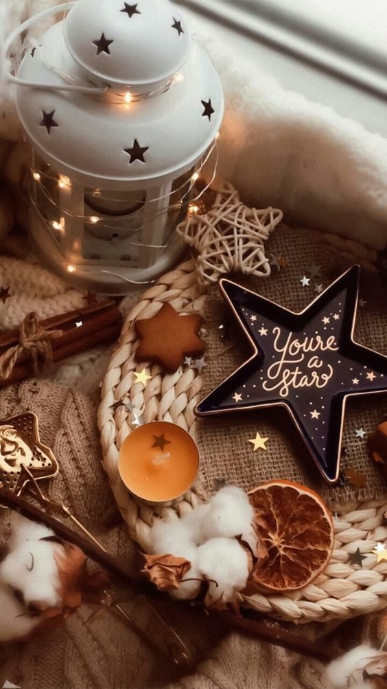 beautiful fall or Thanksgiving decor with a star lantern, star cookies and a dish, cotton, candles and dried citrus slices