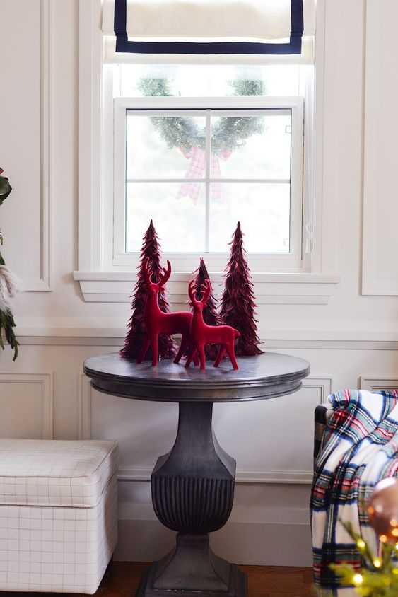 bold Christmas decor done with red feather trees and deer is easy to compose and looks very cool and chic