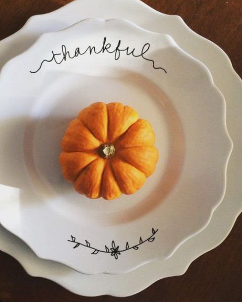 chic white patterned plates and a top one with prints plus a bold and pretty pumpin for a lovely Thanksgiving place setting