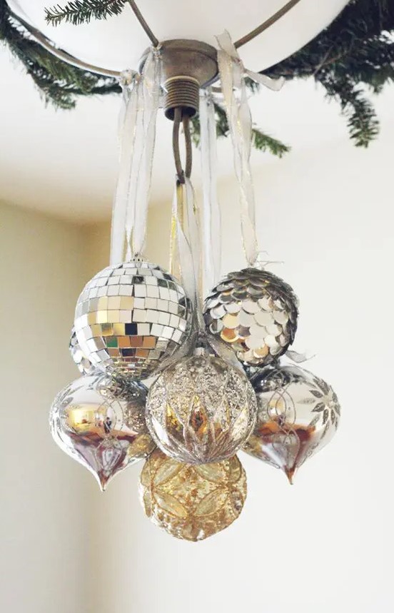 decorate your Christmas chandelier with oversized silver and silver sequin ornaments plus evergreens for an ultimate look