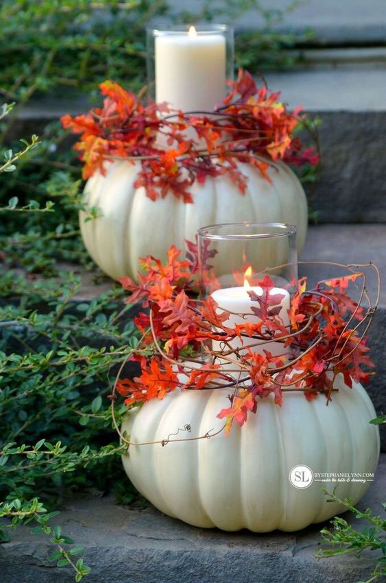 large white pumpkins with pillar candles in the center, with vines and bold leaves are amazing for decorating both indoor and outdoor spaces