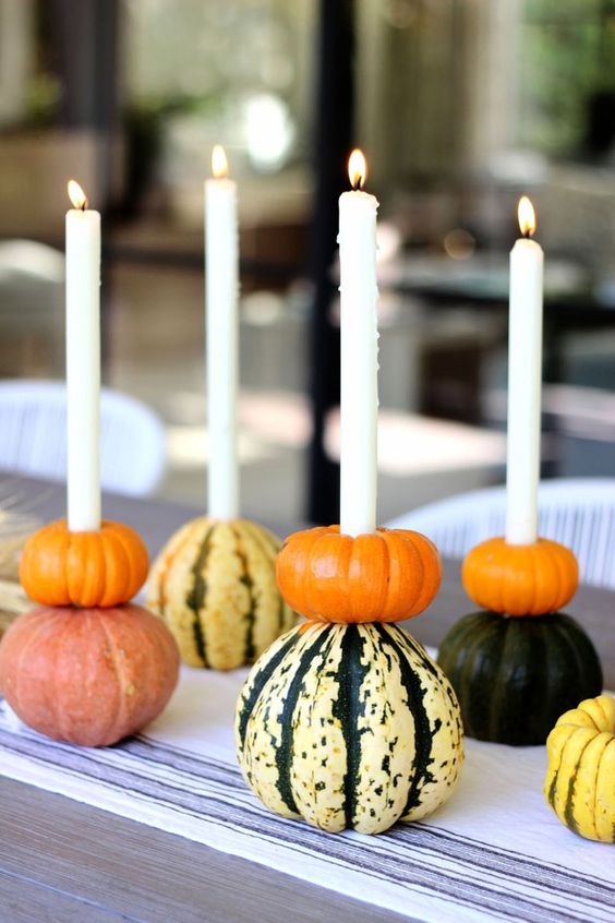 stacked pumpkins with candles integrated are a very natural and very fall-like idea of a Thanksgiving centerpiece that can be DIYed easily