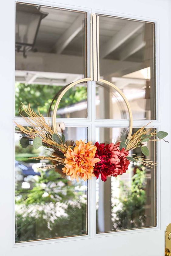 such a cute and bright fall or Thanksgiving wreath with bold blooms, greenery and wheat is a very bold and easy to DIY piece