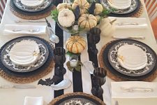 woven placemats, matte black plates and black and white floral ones, a single white pumpkin and small white pumpkin plates on top for a cool fall tablescape