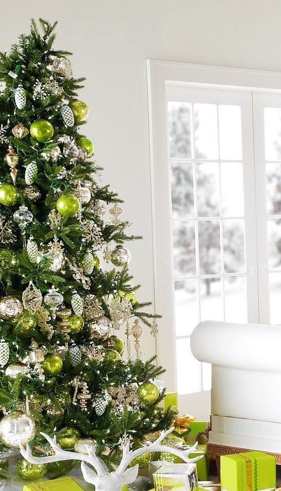 a Christmas tree styled with gold, neutral, neon green ornaments and neon green gift boxes is a cool shiny idea
