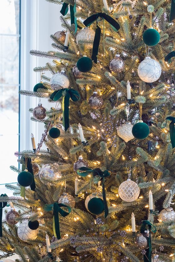 a beautiful Christmas tree with white, metallic, dark green ornaments and ribbon bows plus lights is a stylish idea