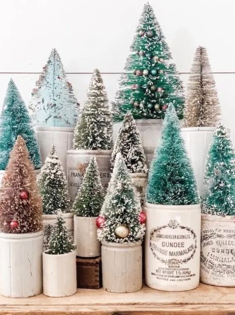 a beautiful arrangement of bottle brush Christmas trees with mini ornaments placed into planters and pots is cool