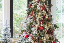 a bold elegant Christmas tree with gold, dark green, red and plaid ornaments, red velvet ribbons, lights and snowflakes is dreamy