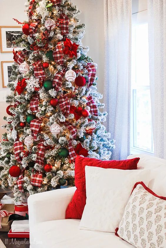a bold flocked Christmas tree with plaid ribbons, red, white and green ornaments, berries and lights is a bold and chic idea