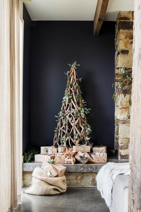 a branch Christmas tree decorated with greenery and white blooms is a very organic and eye-catchy idea to rock