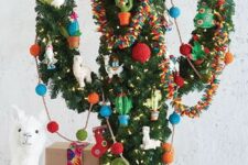 a cactus Christmas tree with colorful ornaments, garlands and lights and little alpaca figurines
