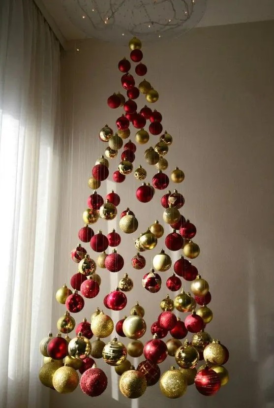 a chic Christmas tree of red and gold glitter, shiny and matte ornaments and lights above it