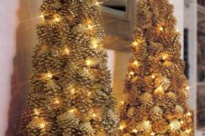 a couple of gilded pinecone Christmas trees decorated with lights look very festive and interesting