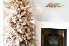 a creamy color pampas grass tree decorated with rose gold, gold and white ornaments plus blooms looks heavenly beautiful