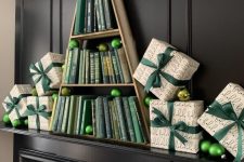 a creative book Christmas mantel with printed gift boxes with green ornaments and a Christmas tree holding green books