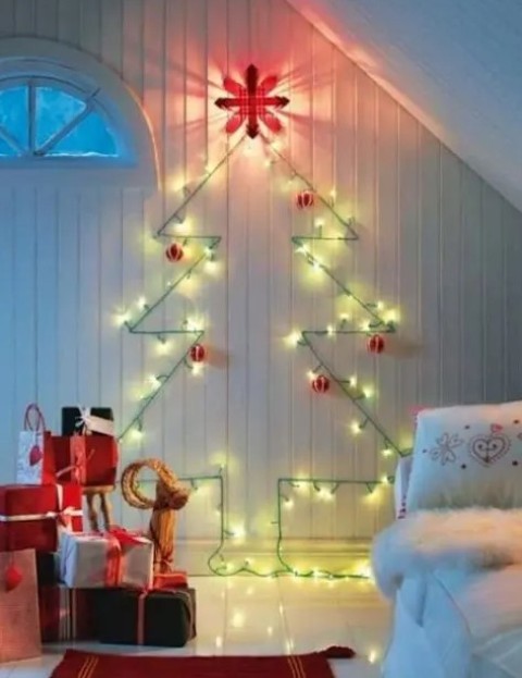 a cute wall-mounted Christmas tree done with green lights and red and white ornaments for a traditional feel