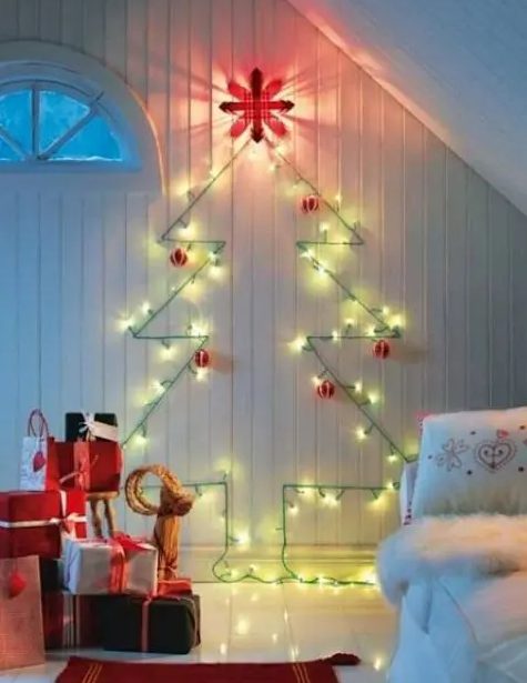 a cute wall-mounted Christmas tree done with green lights and red and white ornaments for a traditional feel