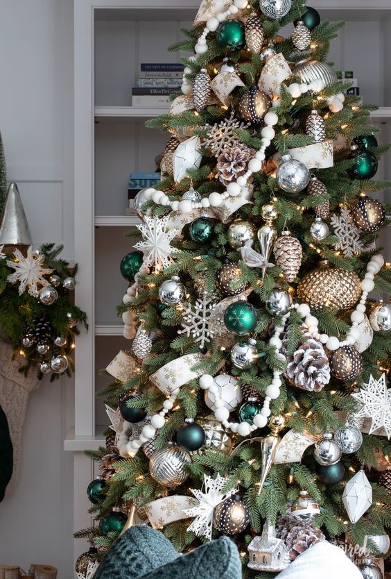 a fabulous Christmas tree with silver and metallic ornaments, bold grene ones, bead garlands, snowy pinecones and snowflakes