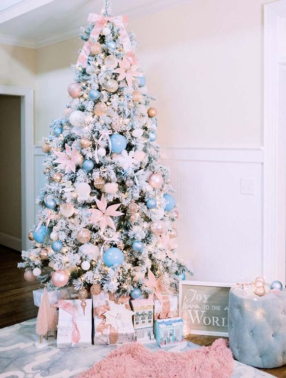 a flocked Christmas tree with blush and light blue ornaments, blush fabric blooms, ribbons and lights is a glam idea to try